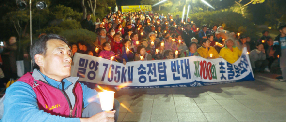 한국전력공사가 초고압 송전탑을 세우려는 데 반대하는 경남 밀양시 단장·산외·상동·부북면 주민들과 시민들이 지난달 24일 밀양시 내일동 영남루에서 ‘밀양 765㎸ 송전탑 반대 제100회 촛불문화제’를 열고 있다. 촛불문화제는 지난해 1월 주민 이치우(74)씨가 송전탑 반대를 외치며 분신 자살한 뒤 시작됐다.   밀양/류우종 기자 wjryu@hani.co.kr
