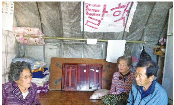 한전의 송전탑 건설장비 진입을 막기 위해 경남 밀양시 부북면 위양리 마을 주민들이 마을 진입로에 움막을 짓고 감시활동을 벌이고 있다.