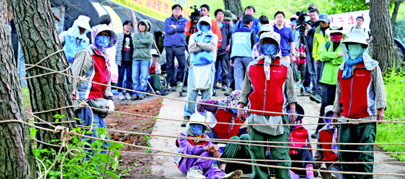 한국전력이 ‘밀양 송전탑’ 공사를 다시 시작한 20일 오후 경남 밀양시 부북면 위양리 위양마을과 대항리 평밭마을 주민들이 마을 어귀 소나무에 줄을 쳐서 공사 장비 등이 들어오지 못하도록 막고 있다. 밀양/김정효 기자 hyopd@hani.co.kr