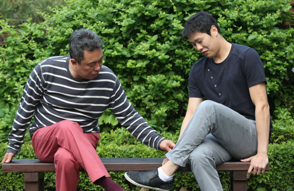 프로농구 케이티(KT)의 전창진 감독이 지난 23일 서울 마포구 공덕동 한겨레 사옥 옥상정원 의자에 앉아 조성민의 바지 끝을 매만져주고 있다. 
 김태형 기자 xogud555@hani.co.kr