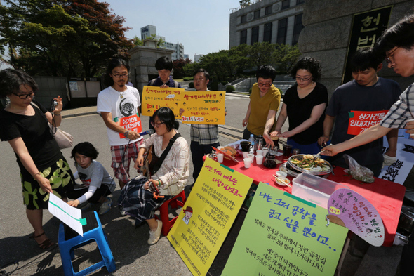 상가임대차보호법의 모순으로 한순간에 모든 것을 잃고 쫓겨나게 된 서울 강남구 신사동 가로수길 ‘리쌍건물’의 임차인 허윤수씨( 오른쪽 두번째)가 10일 오후 서울 종로구 재동 헌법재판소 정문 앞에서 상가임대차보호법에 대해 헌법소원을 제기하겠다고 밝히며 항의의 뜻으로 지지자들과 함께 곱창을 굽고 커피를 내리고 있다.  류우종 기자 wjryu@hani.co.kr