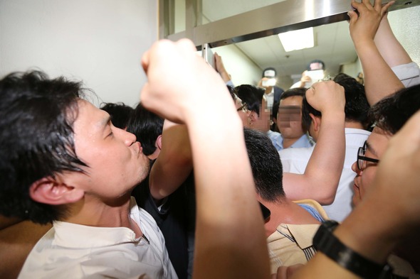 한국일보 기자들이 17일 저녁 서울 남대문로2가 한진빌딩 15층 회사쪽에 의해 봉쇄된 편집국 입구 앞에서 용역업체 직원들과 대치하며 구호를 외치고 있다.  김태형 기자 xogud555@hani.co.kr