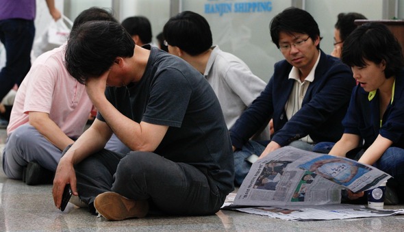 전국언론노동조합 한국일보 지부 조합원들이 18일 오전 회사 쪽이 동원한 용역이 지키고 있는 서울 남대문로 한진해운빌딩 신관 15층 편집국에 들어가지 못한 채 1층 로비에 앉아 있다. 김정효 기자 hyopd@hani.co.kr