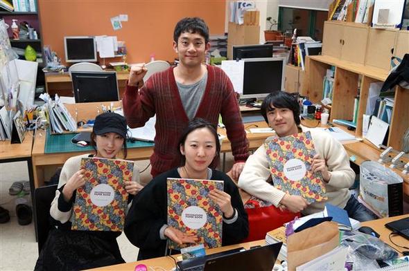 대구에 일본군 위안부 기념관을 지으려 ‘데코레이션 페이퍼북’ 제작 기금 모금에 나섰던 ‘희움 더 클래식’ 직원들이 크라우드펀딩을 통해 모은 돈으로 만든 페이퍼북을 손에 쥐고서 활짝 웃고 있다. 희움 더 클래식 제공
