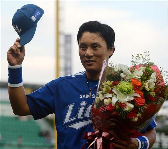 이승엽이 홈런을 친 뒤 축하 꽃다발을 들고 기뻐하고 있다.(왼쪽)