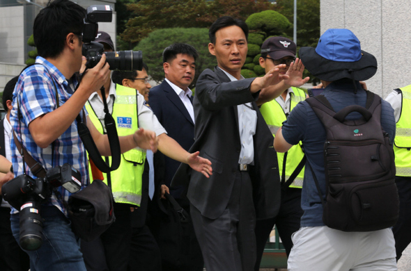 김홍열 통합진보당 경기도당 위원장이 조사를 받기 위해 6일 오전 서울 서초구 내곡동 국정원 앞에 도착하자 경찰들이 취재진의 촬영을 막고 있다. 류우종 기자 wjryu@hani.co.kr