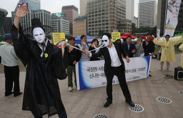 서울민권연대 회원들이 12일 오전 서울광장에서 ‘국가정보원 사망선고 및 신나는 국정원 촛불국민 장례식 선포 기자회견’을 열고 저승사자가 국정원 직원을 끌고가는 행위극을 하고 있다. 이들은 서울광장에 분향소를 설치하고 14일까지 3일간 ‘신나는 국정원 장례식’을 치를 계획이다. 박종식 기자 anaki@hani.co.kr