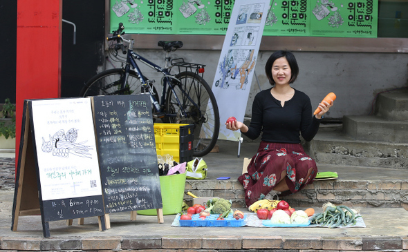 혼자 사는 사람들의 밥을 챙기는 ‘개인주의 야채가게’와 주인 유재인씨. 좌판 옆엔 ‘필요한 만큼만 낱개로 사는 개인주의 야채가게’를 알리는 간판이 서 있다. 신소영 기자 viator@hani.co.kr