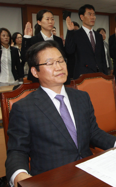 <b>눈감은 전 서울경찰청장</b> 국가정보원 대선개입 수사 은폐·축소 의혹을 받는 김용판 전 서울경찰청장이 15일 오후 서울 서대문구 경찰청 대회의실에서 열린 국회 안전행정위원회의 경찰청 국정감사에서 증인선서를 거부한 채 자리에 앉아 있다. 김 전 청장뒤쪽에 수사 책임자였던 권은희 전 수서경찰서 수사과장(현 송파경찰서 수사과장)이 증인선서를 하고있다. 공동취재사진