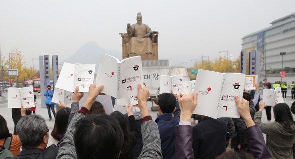 민주노총, 경제민주화국민운동본부 등 21개 시민단체 회원들이 지난 6일 서울 광화문광장에서 열린 ‘박근혜 정부 공약파기 규탄 대회’에서 복지 공약 등이 담긴 대선 당시 박근혜 후보 공약집을 펼쳐 보이고 있다. 박종식 기자 anaki@hani.co.kr