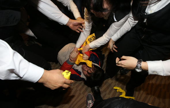  15일 오전 서울 삼성동 코엑스에서 열린 ‘환태평양 경제동반자 협정(TPP)’ 공청회에 참석한 한 여성 농민이 한·중 에프티에이와 티피피를 반대하는 손팻말을 들자 행사 관계자들이 공청회장 밖으로 끌어내고 있다. 신소영 기자 viator@hani.co.kr