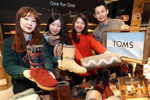 <b>탐스, 무릎담요 이벤트 </b>신발 브랜드인 ‘탐스’ 직원들이 17일 오전 서울 중구 신세계백화점 매장에서 네팔부츠를 구매하는 고객에게 담요를 증정하는 ‘2013년 홀리데이 키트’ 행사를 알리고 있다. 뉴스1