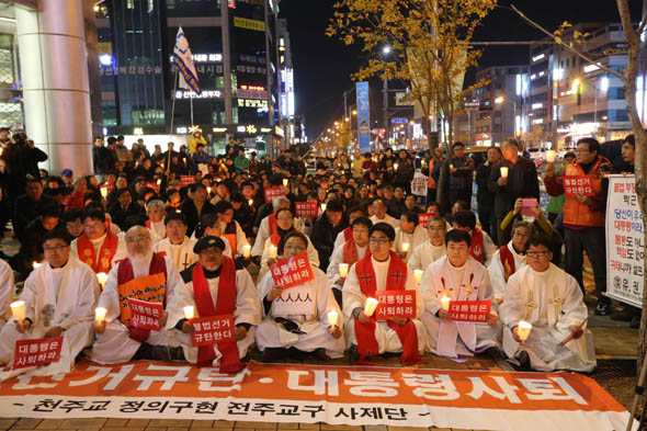 천주교 정의구현 전주교구 사제단 신부들과 신자들이 22일 저녁 전북 군산시 수송동성당에서 시국미사를 마친 뒤 수송동 롯데마트 앞에서 촛불문화제를 열고 있다. 군산/김봉규 선임기자 bong9@hani.co.kr