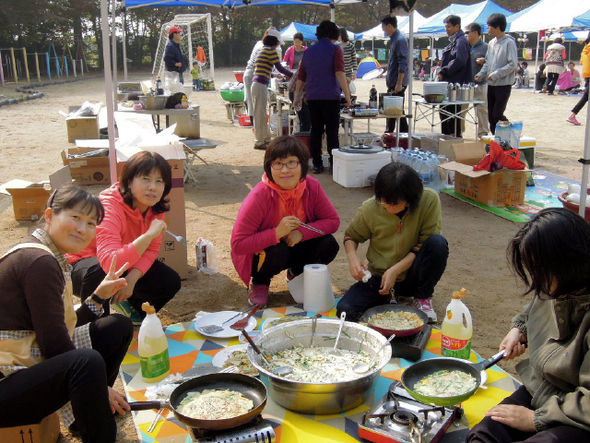 경기도 고양시 덕양구 대장동·내곡동으로 이주한 주민들이 꾸린 영주산마을협동조합이 지난 3일 마을 안 대곡초등학교에서 연 마을 축제에서 아이들이 놀이를 하고(왼쪽) 엄마들이 파전을 부치고 있다.   영주산마을협동조합 제공