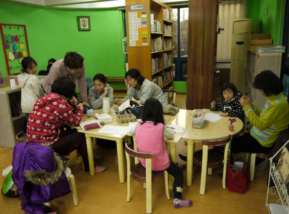 지난 21일 공동육아와 혁신학교 교육을 하러 경기도 고양시 덕양구 대장동·내곡동에 이주한 젊은 주민들이 차린 마을 카페와 동네도서관에서 엄마들이 공예품을 만드는 사이 아이들이 그림을 그리거나 책을 읽고 있다. 고양/박경만 기자