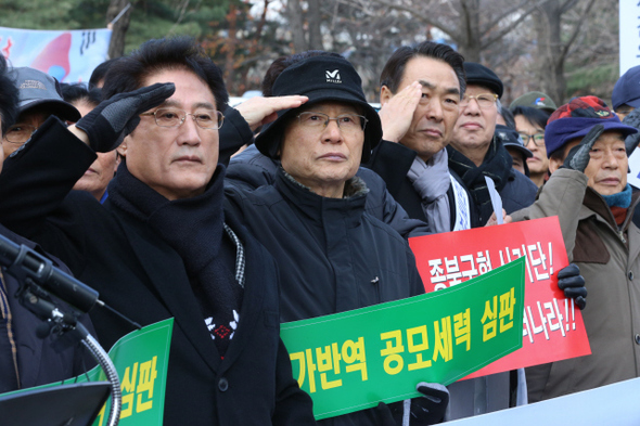 재향군인회 등 15개 보수단체로 이뤄진 호국보훈안보단체연합회 회원들이 26일 오후 서울 송파구 잠실동 천주교 정의구현사제단 사무실 앞에서 연 ‘전주교구 박창신 원로신부 연평도 포격 관련 발언 규탄’ 집회에서 국민의례로 거수경례를 하고 있다. 김태형 기자 xogud555@hani.co.kr