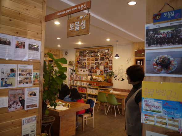 북카페 보물섬 입구에서 본 내부 모습. 보물섬을 꾸리는 데 큰 구실을 한 김종례(오른쪽)씨가 북카페 안을 둘러보고 있다. 박임근 기자