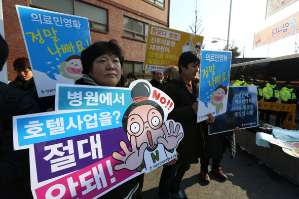 전국보건의료산업노동조합 조합원들이 23일 오전 서울시 종로구 청운효자동주민센터 앞에서 기자회견을 열어 의료 민영화 정책 폐기와 진주의료원 재개원을 촉구하고 있다. 이들은 기자회견 뒤 각자 적은 대자보를 붙이려다 이를 막는 경찰과 몸싸움을 벌였다. 강창광 기자 chang@hani.co.kr