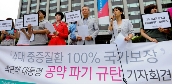건강세상네트워크와 경제정의실천시민연합 등 건강보험가입자포럼 참여단체 대표들이 지난 6월26일 서울 계동 보건복지부 앞에서 기자회견을 열어 박근혜 대통령의 대선공약 ‘4대 중증질환 100% 국가보장’이 선거용 거짓공약이라며 실효성 있는 대안 마련을 요구하고 있다. 김정효 기자 hyopd@hani.co.kr