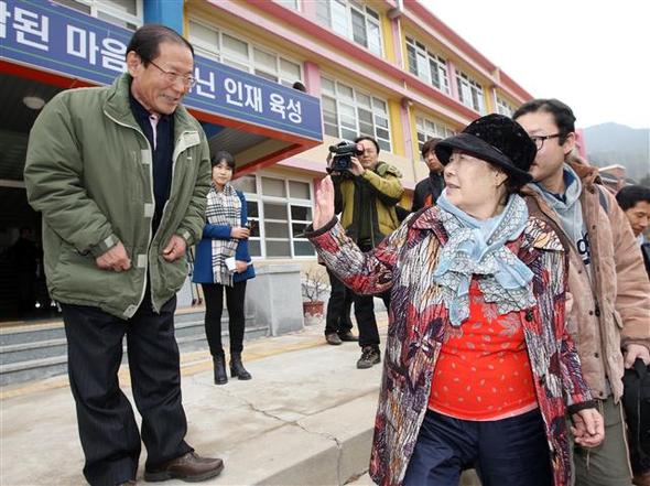 위안부 할머니 앞에선 청송여고 교장　대구에 사는 일본군 위안부 피해자인 이용수 할머니가 8일 교학사 한국사 교과서를 채택한 경북 청송군 청송여고에서 박지학 교장의 교과서 선정 재논의 약속을 받은 뒤 학교를 나서고 있다. 청송여고는 역사교과서 채택 과정에서 교과서 선정 기준표 및 절차 공개, 교과협의회 구성 등 절차를 제대로 거치지 않은 것으로 드러났다. 청송/연합뉴스