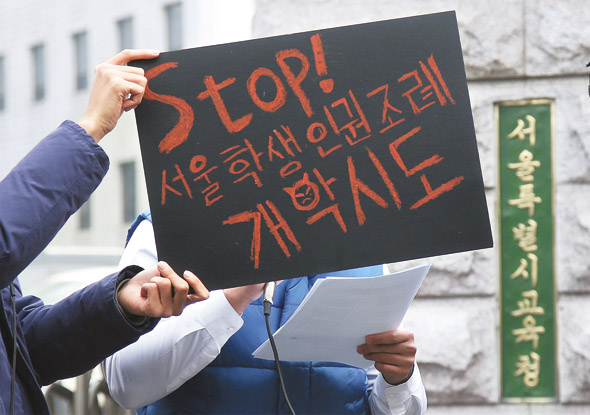 한 고등학생이 8일 오전 서울 종로구 신문로2가 서울시교육청 앞에서 열린 ‘서울학생인권조례 개악시도 반대 공동기자회견’에 참석해 시교육청이 입법예고한 ‘서울학생인권조례 개정안’의 내용을 반대하는 발언을 하고 있다. 서울시내 한 고등학교에 재학중이어서 얼굴이 밝혀지기를 꺼리는 이 학생의 얼굴을 다른 참가자가 서울학생인권조례 개악 반대의 내용이 적힌 손팻말로 가려주고 있다. 
신소영 기자 viator@hani.co.kr