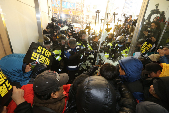 지난달 22일 경찰이 철도노조 집행부 체포영장을 집행하겠다며 민주노총이 세들어 있는 경향신문사 1층 로비 유리문을 부수고 있다.  박종식 기자 anaki@hani.co.kr