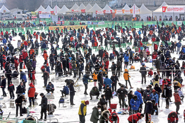 주말을 맞은 19일 강원 화천군 화천읍 화천천에서 열린 ‘2014 산천어축제‘에 수많은 관광객이 찾아 얼음구멍에 낚시대를 드리우고 낚시를 하며 겨울 추억을 만들고 있다. 화천군은 지난 4일 개막한 이후 개막 3주째를 맞은 19일까지 관광객 100만명을 돌파했다고 밝혔다.   2014.1.19. 화천=연합뉴스