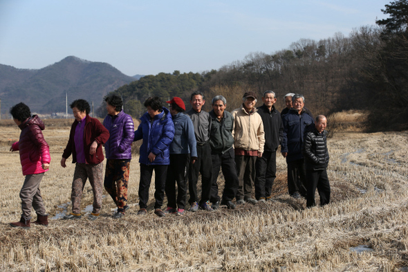 ‘닭 키우는 농부 시인’ 홍일선씨(오른쪽 다섯째)가 5일 오후 경기도 여주시 점동면 도리 마을 논두렁에서 시를 나눠준 주민들과 함께 이야기하며 웃고 있다.