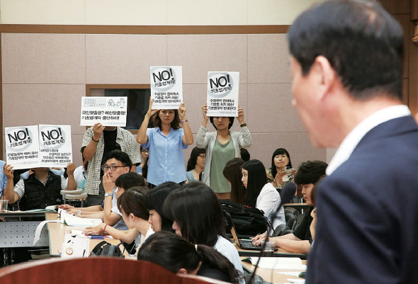 지난해 6월 서울 불광동 한국보건사회연구원에서 열린 ‘기초생활보장 맞춤형 개별급여 개편방향 공청회’에서 진영 당시 보건복지부 장관이 인사말을 하는 동안 시민사회 활동가들이 ‘No! 기초법 개악’이라고 쓴 손팻말을 들고 침묵시위를 하고 있다. 연합뉴스