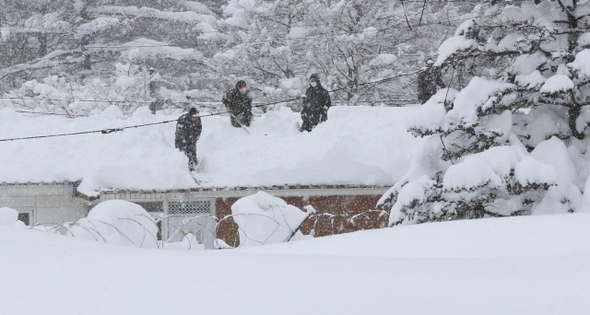 강원도 동해안에 폭설이 닷새째 내린 10일 오후 고성군 간성읍 군부대에서 병사들이 건물 지붕 위에 올라가 쌓인 눈을 치우고 있다. 고성/박종식 기자 anaki@hani.co.kr