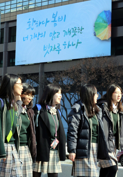 3일 낮 서울 광화문 교보생명빌딩에 새로 내걸린 ‘광화문 글판’ 봄편 앞으로 학생들이 지나가고 있다. 1년에 4번, 계절의 변화에 따라 새롭게 내걸리는 광화문 글판의 이번 봄 글은 박남준의 시 ‘깨끗한 빗자루’에서 가져왔다. 김태형 기자 xogud555@hani.co.kr