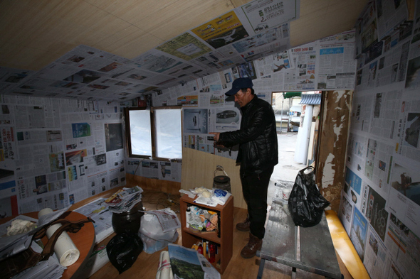 지난달 17일 불이 나 집 안 곳곳이 그을린 화교사옥 2층 쪽방에서 집주인 나아무개씨가 10일 오후 나무판자로 무너진 벽을 덧대고 신문지를 붙이는 등 임시로 수리한 방 안을 보여주고 있다. 건물 관리 주체인 한성화교협회는 이날 이 쪽방이 전소된 건물에 불법으로 지은 건축물이라며 철거를 시도했다. 류우종 기자 wjryu@hani.co.kr