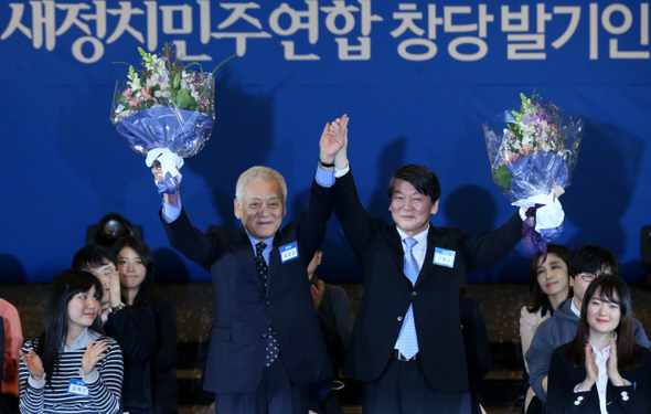 새정치민주연합 창당준비위원회 공동위원장으로 선출된 김한길 민주당 대표(왼쪽)와 안철수 새정치연합 중앙운영위원장이 16일 오후 서울 세종로 세종홀에서 열린 창당발기인대회에서 손을 맞잡은 채 꽃다발을 흔들어 참석자들에게 인사하고 있다. 이정우 선임기자 woo@hani.co.kr