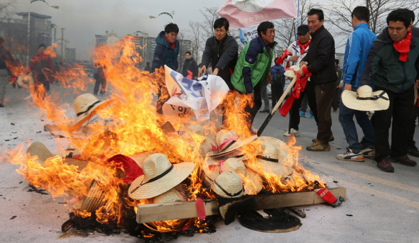 농민들이 17일 오후 경기도 고양시 일산서구 킨텍스 앞에서 한-중 자유무역협정(FTA) 추진 중단, 한-오스트레일리아 및 한-캐나다 자유무역협정 철회를 요구하는 행진을 마친 뒤 상여와 중국산 밀짚모자를 태우고 있다. 고양/김태형 기자 xogud555@hani.co.kr