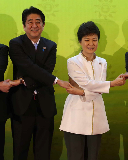 박근혜 대통령이 2013년 10월10일 브루나이에서 열린 아세안+3 정상회의에 앞서 아베 신조 일본 총리 등 참석자들과 손을 잡고 기념사진을 찍고 있다.