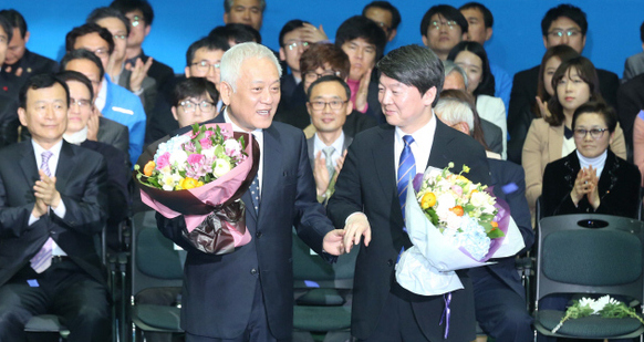 새정치민주연합 공동대표로 선출된 안철수(오른쪽), 김한길 의원이 26일 오후 서울 송파구 올림픽공원 올림픽홀에서 열린 중앙당 창당대회에서 꽃다발을 든 채 함께 무대 한가운데로 걸어나오고 있다. 오른편 빈자리는 천안함 순국 장병을 추모하기 위해 마련된 것으로 두 대표가 국화를 올려놓았다.  이정우 선임기자 woo@hani.co.kr