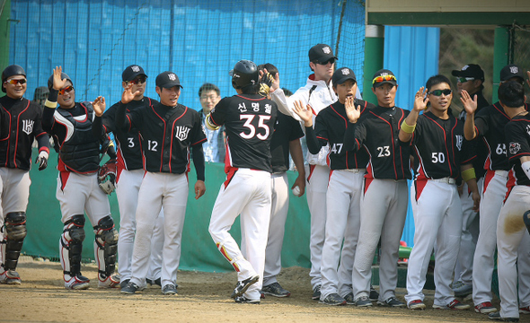 케이티(KT) 선수들이 1일 경찰청과의 퓨처스리그 데뷔 경기에서 팀 창단 후 첫 홈런을 친 신명철이 더그아웃에 들어서자 손을 맞추며 환영하고 있다. 케이티 제공