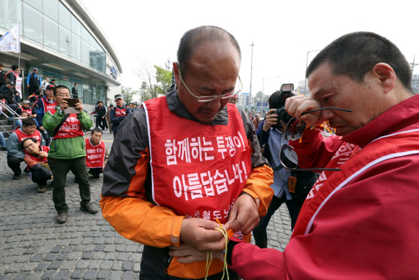 전국철도노동조합 서울지역 운전조합원들이 15일 오후 서울 용산구 동자동 공항철도 광장에서 강제전출 철회를 촉구하며 연 전출입자 환송 및 환영 집회에서 전출자들의 손목에 ‘반드시 다시 돌아오라’는 의미로 오색실을 묶어주고 있다. 
김태형 기자 xogud555@hani.co.kr