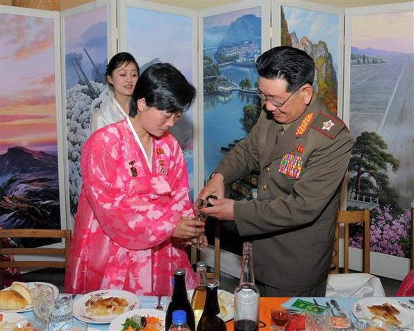 황병서 북한 인민군 총정치국장(오른쪽)이 1일 김정숙 평양방직공장 노동자 기숙사에서 열린 5·1절 경축 노동자연회에서 ‘영웅’ 메달을 가슴에 단 여성 노동자에게 술을 따라주고 있다. 평양/조선중앙통신 연합뉴스