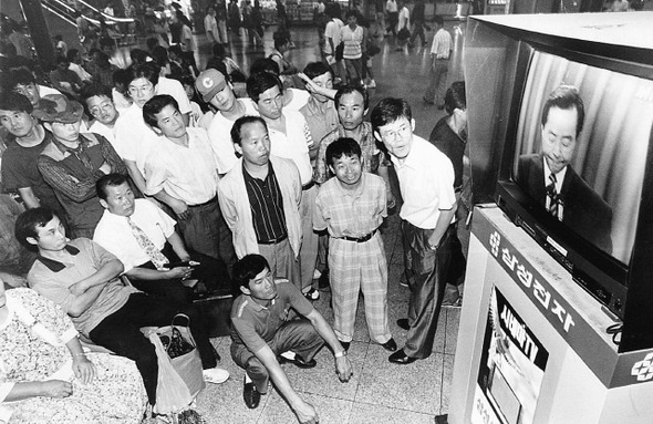 1993년 8월 김영삼 대통령의 ‘금융실명제에 관한 특별담화’ 발표를 서울역에서 열차를 기다리던 시민들이 텔레비전을 통해 보고 있다. <한겨레> 자료사진