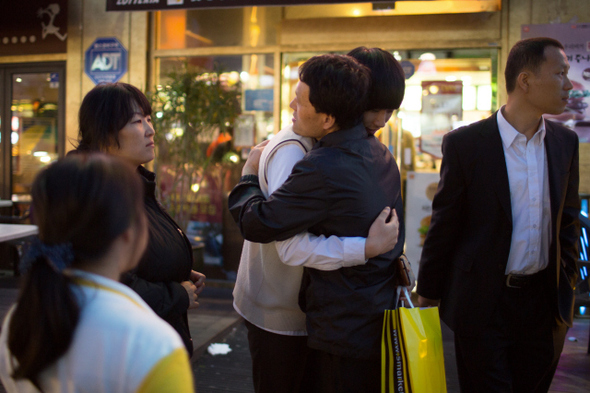 <b>[고맙구나]</b> 박창국(45)씨가 지난 6일 저녁 경기도 안산시 단원구 선부동 인근에 위치한 상가에서 장례식 때 아들 박성복군의 영정사진을 들었던 김민수(18·단원고3)군에게 새 신발을 선물한 뒤 끌어안고 있다. 박씨는 장례식에서 김군이 구멍난 헌 신을 신은 채 영정사진을 들고 있던 걸 보고서 새 신을 꼭 사줘야겠다고 생각했다고 전했다.