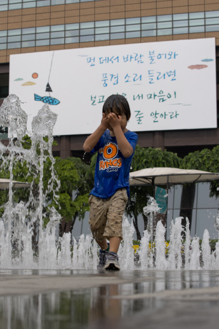 서울의 낮 최고기온이 27도에 이르는 등 여름날씨가 이어진 19일 오후 서울 종로구 광화문 광장 분수대에서 신윤섭(4)군이 물놀이를 하고 있다. 그 뒤로 정호승 시인의 시 ‘풍경 달다’에서 발췌한 “먼 데서 바람 불어와 풍경소리 들리면…”으로 이어지는 교보생명빌딩의 광화문글판 여름편이 걸려 있다.
김성광 기자 flysg2@hani.co.kr