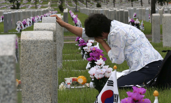 현충일을 하루 앞둔 5일 오전 서울 동작구 국립현충원을 찾은 한 유족이 묘비 앞에서 흐느끼고 있다. 국가보훈처는 6일 오전 9시55분 국립서울현충원 현충문 앞 광장에서 순국선열과 호국영령의 얼을 기리고 추모하는 제59회 현충일 추념식을 연다.  류우종 기자 wjryu@hani.co.kr