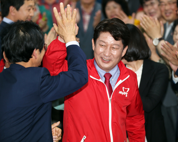 권영진 새누리당 대구시장 당선자가 4일 밤 승리가 확실시되자 선거캠프로 들어서며 한 지지자와 손을 맞추고 있다. 대구/연합뉴스