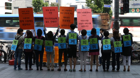 한국여성민우회 회원들이 12일 오전 서울 영등포구 롯데백화점 앞에서 ‘백화점 판매직 노동자의 인권적 노동환경 만들기’ 기자회견을 열고 커다란 손팻말을 든 채 오가는 시민에게 홍보하고 있다.  이종근 기자 root2@hani.co.kr