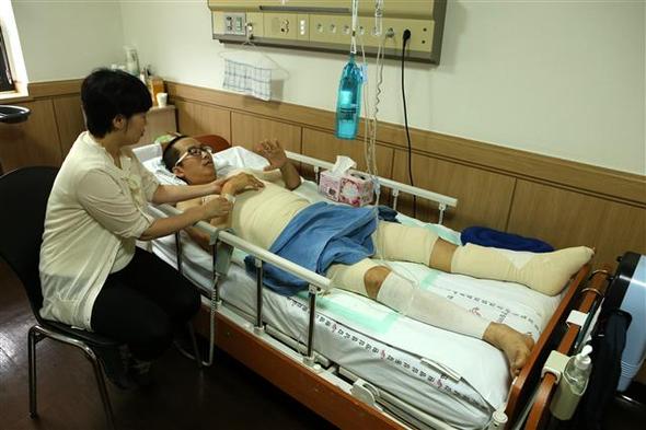 경기도 고양종합터미널 화재사건이 발생한 지 한 달을 맞은 25일, 서울 한강성심병원에 입원해 치료를 받고 있는 불이학교 박성린 교사가 온몸에 붕대를 감고 부인의 보살핌을 받고 있다. 박 교사는 온몸에 심한 화상을 입어 3차례 피부이식 수술 등을 받았다. 고양/박경만 기자 mania@hani.co.kr