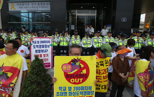 한국마사회가 지역 주민의 반발에도 28일 오전 서울 용산구 한강로3가 마권장외발매소(화상경마장)를  시범 개장하자 주민들이 발매소 입구를 가로막으며  화상경마장 개장를 반대하고 있다. 마사회는 당초 화상경마장을 작년 9월 개장할 예정이었으나 주민과 시민단체의 반발로 개장 계획을 늦춰왔다.지역 주민들은 화상경마장 인근 지역에 주택가가 밀집해 있고 원효초, 성심여중고 등 학교가 자리 잡고 있다는 점 등을 이유로 화상경마장 개장을 반대하고 있다. 신소영 기자 viator@hani.co.kr