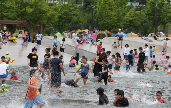 서울 최고기온이 31도까지 오른 6월1일 서울 한강시민공원 여의도지구 물빛광장을 찾은 어린이들이 물놀이를 하며 더위를 식히고 있다.
 이종근 기자 root2@hani.co.kr