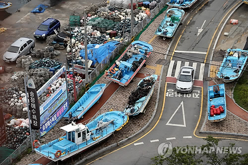 제8호 태풍 ‘너구리’가 북상하고 있는 가운데 7일 부산 해운대구 송정해수욕장 인근 도로에 태풍에 대비해 미리 옮겨진 어선들이 줄지어 서 있다. 연합 제8호 태풍 ‘너구리’가 북상하고 있는 가운데 7일 부산 해운대구 송정해수욕장 인근 도로에 태풍에 대비해 미리 옮겨진 어선들이 줄지어 서 있다. 연합