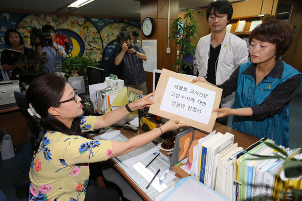 세월호 참사와 관련해 진상 규명 및 책임자 처벌 등을 요구하는 교사선언에 참여한 교사들에 대한 교육부의 고소·고발 및 징계 추진과 관련해 이영주 전교조 수석부위원장(오른쪽)이 16일 오전 서울 중구 국가인권위원회에 이런 행위의 중단을 촉구하는 진정서를 제출하고 있다.  김태형 기자 xogud555@hani.co.kr